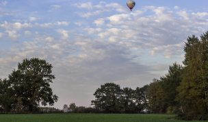 Hintergrundbild - Heißluftballon über Landschaft